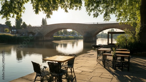 Beautiful bridge reflecting in calm water during golden hour in a quaint rive...