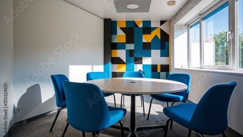 Small meeting room with colorful geometric wall and blue chairs