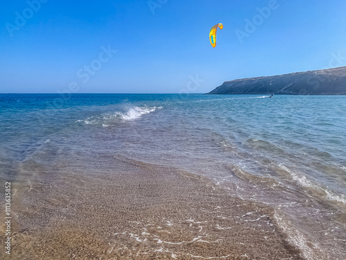 Kitesurfing adventure in clear waters on a sunny coastal day. High quality photo