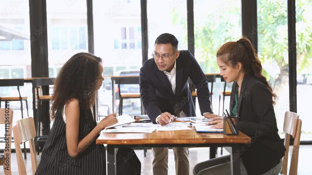 Business Team Meeting Cafe: A focused business team collaborates on paperwork during a meeting in a modern cafe setting. The scene exudes professionalism and synergy. Business Team Meeting Cafe: A focused business team collaborates on paperwork during a meeting in a modern cafe setting. The scene exudes professionalism and synergy.