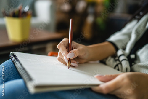 Woman sketch and draw on a blank notebook with a wooden crayon in hand