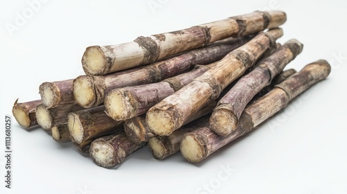 A heap of sugarcane stalks, earthy tones in focus, resting on an untextured white background photo