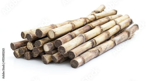 A heap of sugarcane stalks, earthy tones in focus, resting on an untextured white background