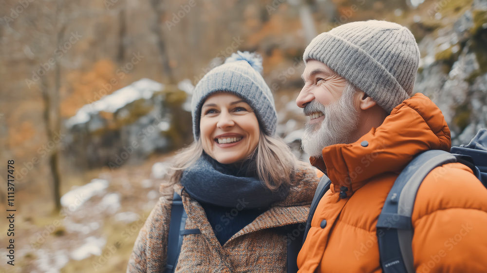 Fototapeta premium A happy middle-aged couple enjoys a hiking adventure in a lush forest, smiling brightly with backpacks, embracing nature, and celebrating an active, outdoor lifestyle.