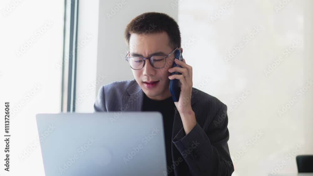 Serious young adult male working in office workplace Serious young adult male working in office workplace
