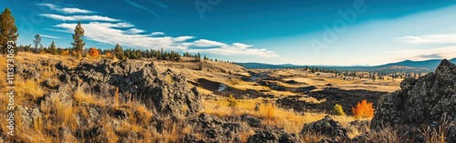 The expansive terrain of Craters of the Moon showcases rugged lava fields and colorful autumn foliage under a clear blue sky, inviting exploration and adventure.