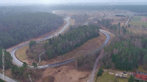 Aerial descent over Nemunas Ring Race Track, foggy day, surrounded by lush forests photo