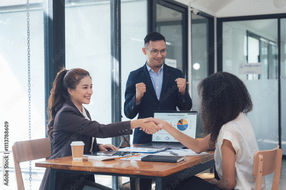 Obraz premium Successful Business Deal: A diverse team celebrates a successful business deal with a handshake, signifying trust, collaboration, and mutual success. The atmosphere is one of joy and accomplishment. 