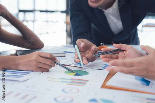 Teamwork Makes the Dream Work: A close-up shot focusing on hands actively engaged in analyzing financial charts and graphs, symbolizing collaboration, strategic planning, and successful teamwork.