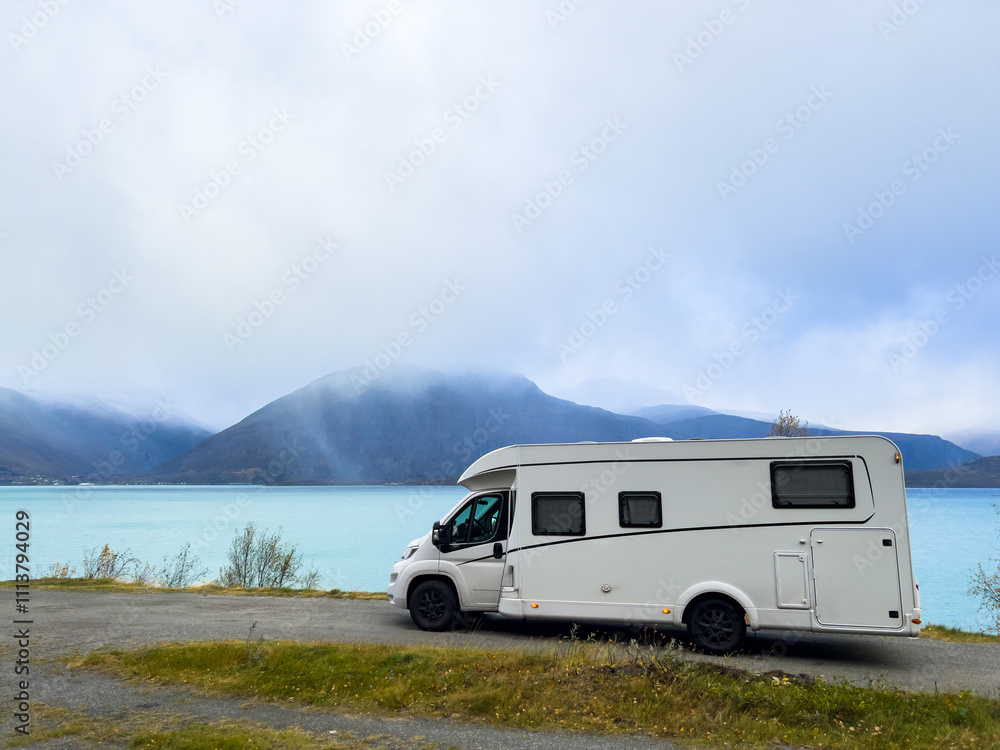 A motorhome parked by the road in the autumn landscape of the Lyngen Alps, Northern Norway, with mountains. A motorhome parked by the road in the autumn landscape of the Lyngen Alps, Northern Norway, with mountains.