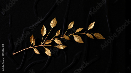 Golden olive branch on textured black fabric