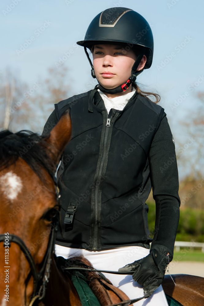 Close-up of a beautiful young rider and her mare in competition attire Close-up of a beautiful young rider and her mare in competition attire