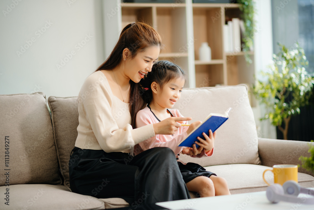 A caring mother and young daughter share a bonding moment doing homework at home. A caring mother and young daughter share a bonding moment doing homework at home.