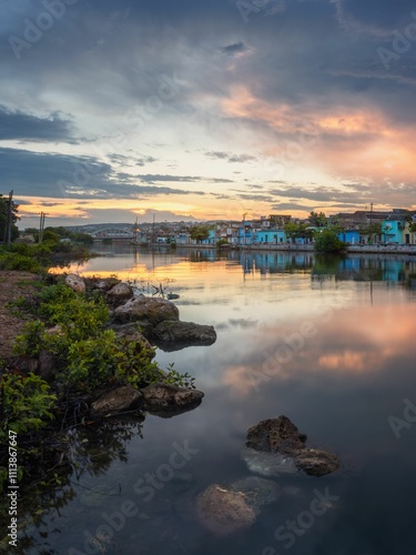 Tranquil river at sunset with colorful reflections.