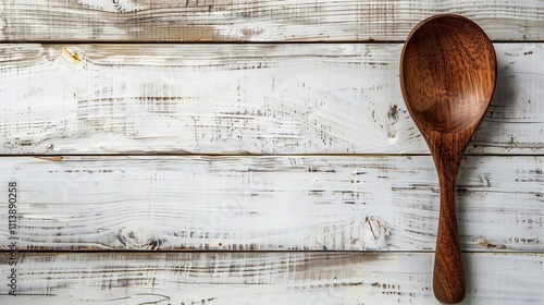 wooden spoon laid on a wooden table with white background.