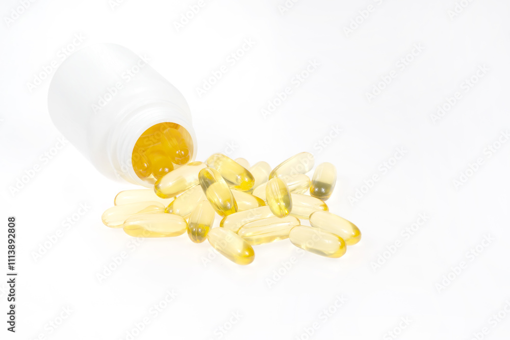 Omega 3 tablets spilling out of pill bottle isolated on white background. yellow pills close up. Fish oil capsules. Golden vitamin D3 Omega 3 tablets spilling out of pill bottle isolated on white background. yellow pills close up. Fish oil capsules. Golden vitamin D3