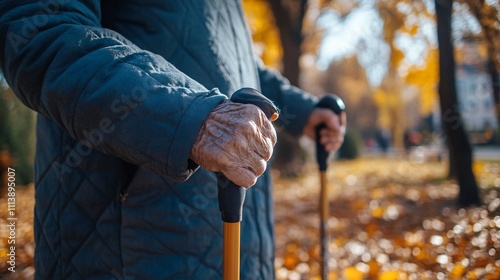 Senior woman holding trekking poles while walking in autumn park