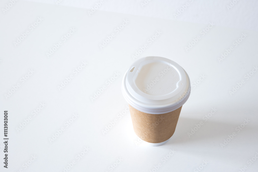 Empty, plastic, generic take-away coffee cup with brown cardboard paper wrapping, isolated on white. Close up shot, no branding, no logos, no people Empty, plastic, generic take-away coffee cup with brown cardboard paper wrapping, isolated on white. Close up shot, no branding, no logos, no people