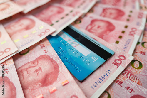 a blue plastic card on a background of money. Close-up credit card and Chinese yuan cash. photo