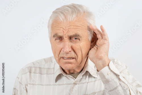 Senior man holding his hand near his ear. Older man suffers from hearing problems, deafness