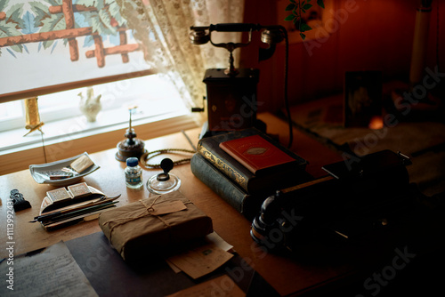 Vintage desk with anti0ue telephone, writing materials, and ornate decoration in a dimly lit room, Trondheim, Norway
