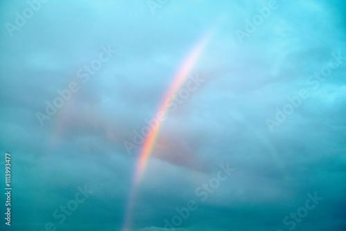 A vibrant rainbow arcs through a cloudy sky, Norway photo