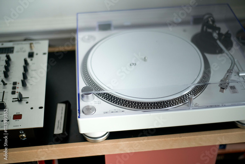 Close-up of a modern turntable with DJ e0uipment on a desk, highlighting the intricate details and controls for music playback.