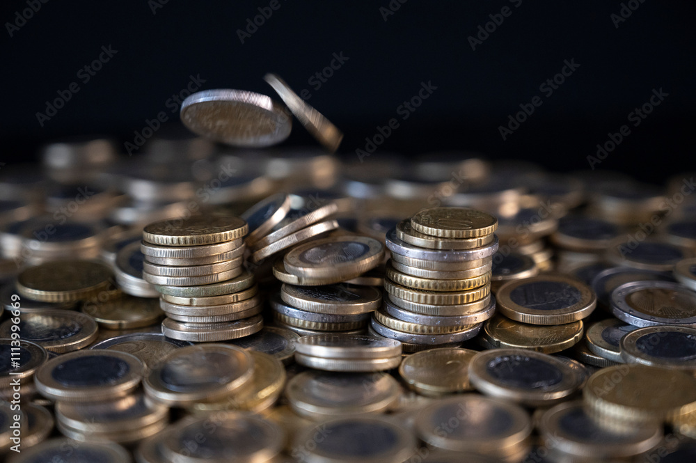 Euro coins falling onto a pile of additional money Euro coins falling onto a pile of additional money