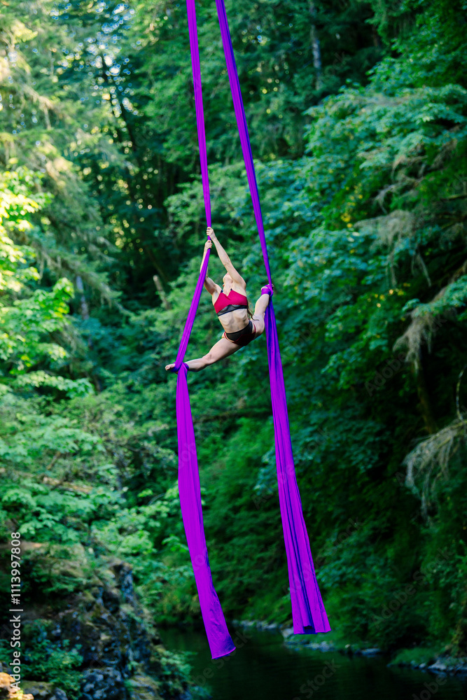 © Connect Images - Performer demonstrating aerial silks acrobatics surrounded by lush greenery, USA © Connect Images - Performer demonstrating aerial silks acrobatics surrounded by lush greenery, USA