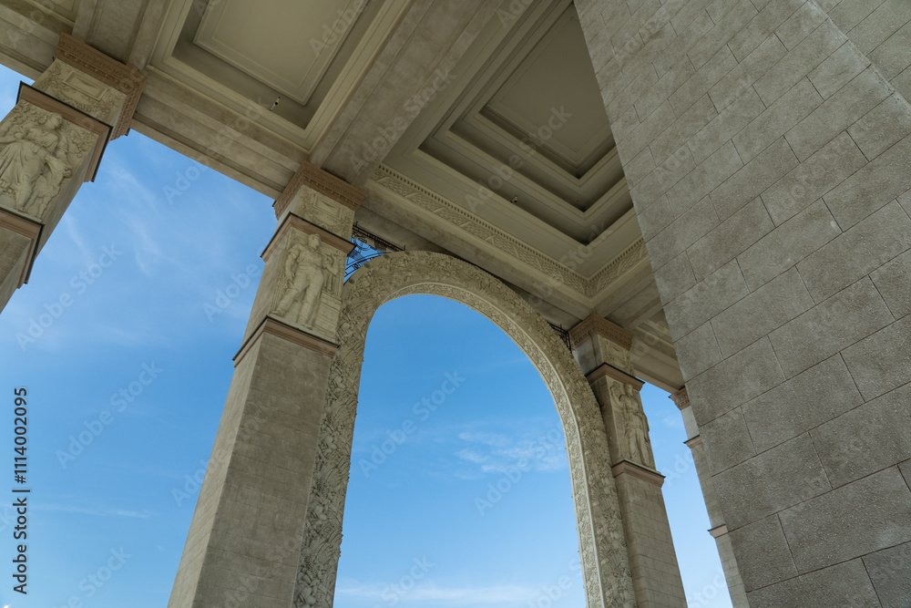 Fototapeta premium Tall, massive columns of a vintage, old building. Bottom-up view