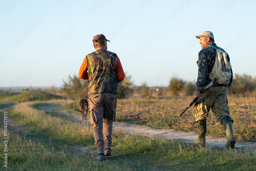 Mature hunter man holding a shotgun and walking through a field Mature hunter man holding a shotgun and walking through a field