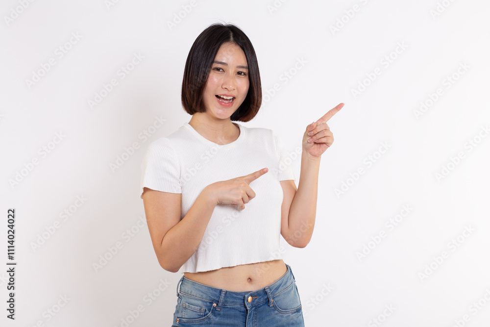 portrait of a Happy Asian woman smiling points her index finger at an empty space in the background and looks straight ahead on white background portrait of a Happy Asian woman smiling points her index finger at an empty space in the background and looks straight ahead on white background