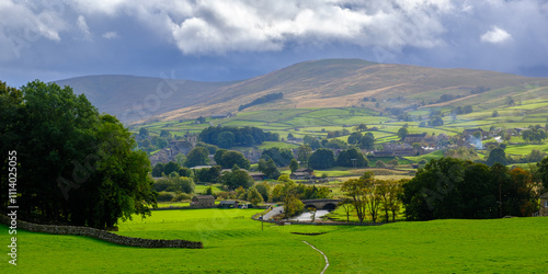 Rainclouds view across the fields to Hawes in Wensleydale, Yorkshire, UK