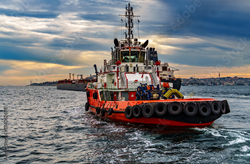 A large tanker ship and tug boat sails along the Bosphorus against the background of Istanbul, Turkey, a view from a pleasure boat photo