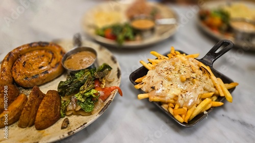 mouthwatering German worst curled up cumberland sausage meal featuring a grilled sausage, loaded cheese fries, and fresh vegetables served on a rustic plate photo