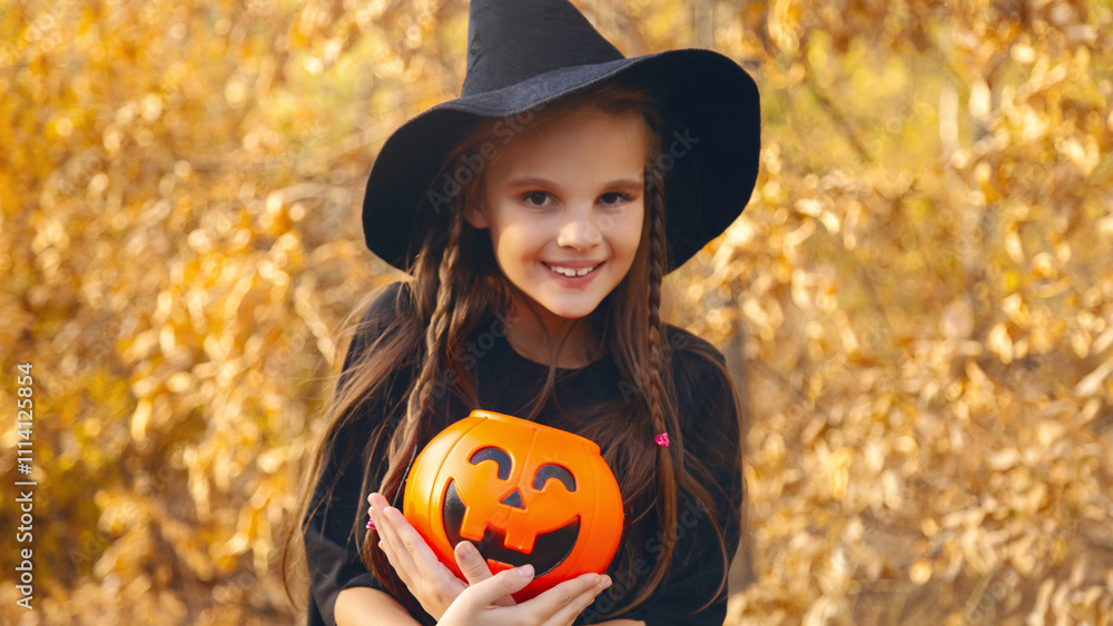 Lifestyle cute smiling emotional 8-9 years old walking in the autumn park wearing a wicth costume. Funny child holding a pumpkin basket for candy and ready for a Halloween party. Lifestyle cute smiling emotional 8-9 years old walking in the autumn park wearing a wicth costume. Funny child holding a pumpkin basket for candy and ready for a Halloween party.