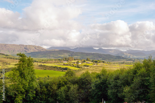 Wallpaper Mural A beautiful landscape with a cloudy sky and mountains in the background Torontodigital.ca