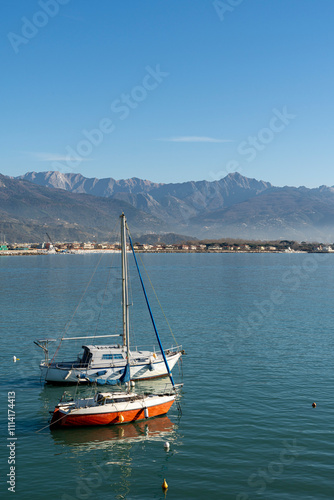 Tuscany, pleasure sailboats moored in the AMrina di Carrara marina, with the Apuan Alps in the background