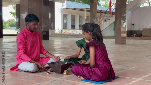 A Hindu family gathered around a sacred fire, performing a Yagya or havan photo