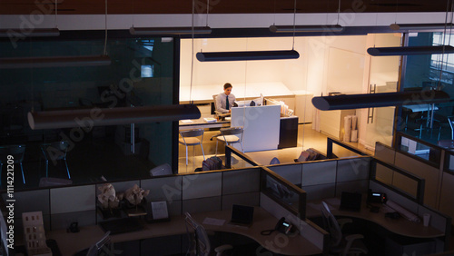 Fotografía Wide Angle Shot Of Businessman At Desk Working Late At Night In Empty Office