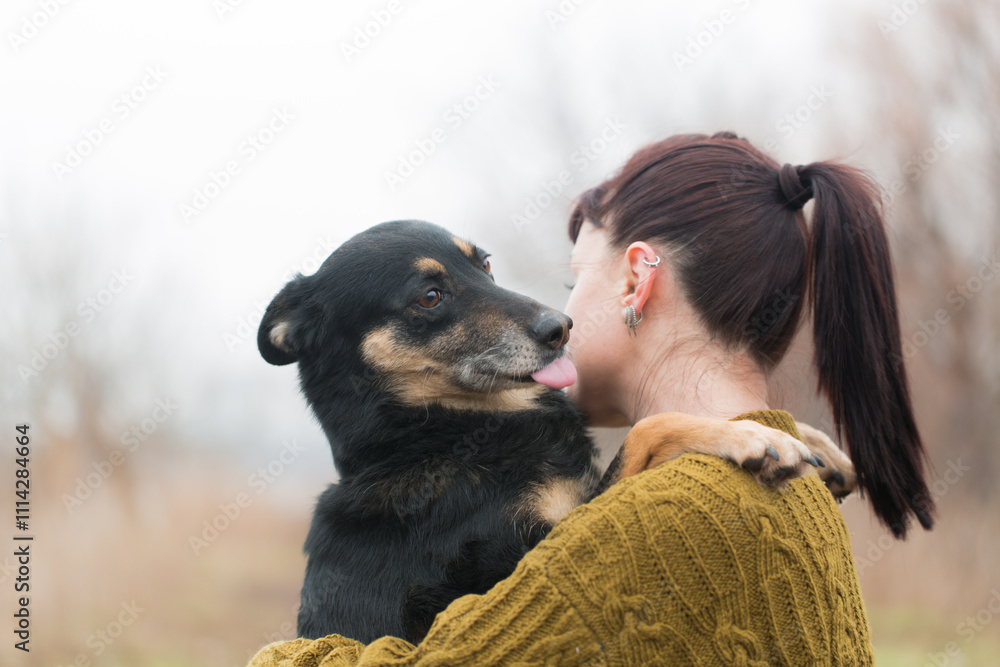 Woman and dog hugging on a walk
