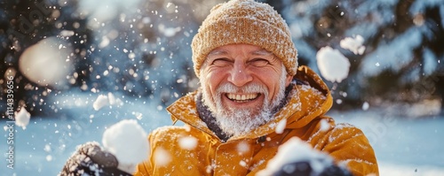 Portrait of happy senior man in winter during snow having fun with family outdoors playing snowballs fight. Active healthy lifestyle in retirement