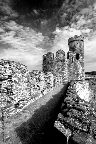 One of the broken towers of Conwy castle in black and white. Conwy Castle is one of the many Medieval Castles built by Edward I, in the 13th century as part of his conquest of Wales. photo