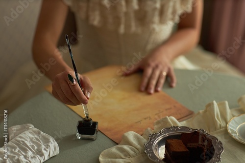 Konstfotografi Top view closeup of lady writing letter with female hand dipping ornate ink pen