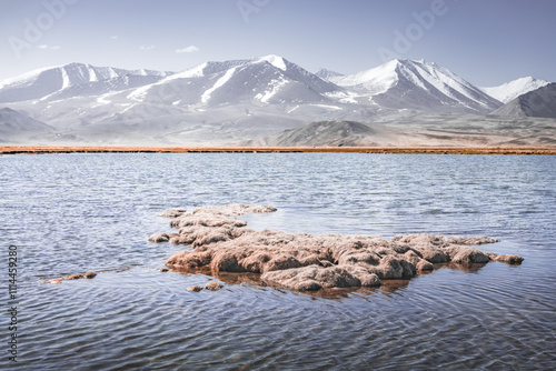 Panorama of a high-mountain landscape, a lake and a river in the mountains flows in a mountain valley among meadows against the background of mountains, landscape in the Pamir Mountains background photo