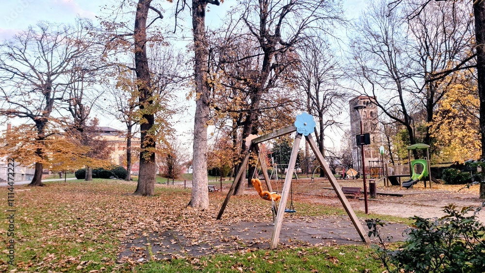Outdoor Playground in Autumn with Tall Trees and Dry Leaves Scattered on the Ground, in a Nostalgic and Peaceful Setting Outdoor Playground in Autumn with Tall Trees and Dry Leaves Scattered on the Ground, in a Nostalgic and Peaceful Setting