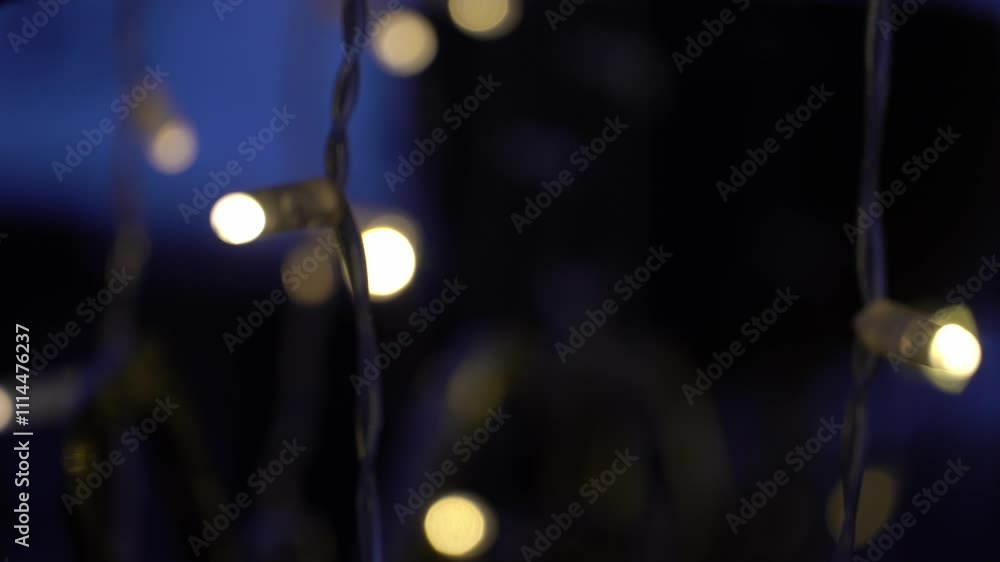 New Year decorations. Hanging sparkling garlands. Bright light bulbs blink decorating the room. Christmas and New Year. Selective focus.