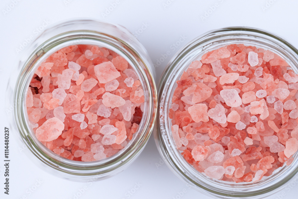 A jar of pink salt on a white surface. A sea of salt on a white background. Sea salt white background jar pink lies. A pink jar of salt lies on a white lifestyle background. A jar of pink salt on a white surface. A sea of salt on a white background. Sea salt white background jar pink lies. A pink jar of salt lies on a white lifestyle background.