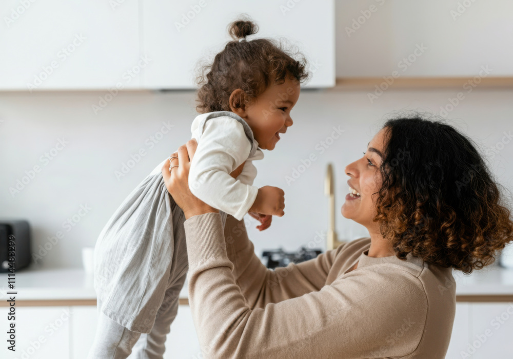 Happy mother lifting her baby daughter in the air, enjoying precious moments at home Happy mother lifting her baby daughter in the air, enjoying precious moments at home