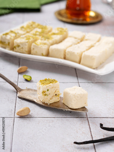 Turkish vatka - tender pashmak halva on a plate, in the form of square cubes, with a cup of Turkish tea. photo